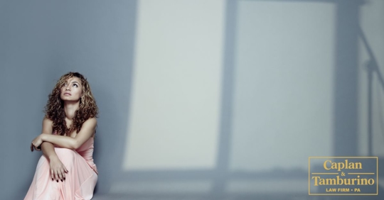 Woman sitting down on the floor against a wall